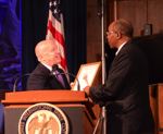 House Ways and Means Committee Chairman Kevin Brady (R-TX) presenting Chairman Irving Williamson with an  excerpt of his statement for the Congressional record about the USITC's  hundred years of service.