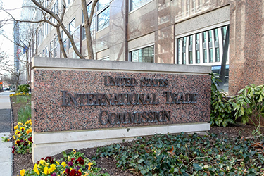 Stone sign with dark text of "United States International Trade Commission" in front of the USITC building in Washington, D.C.