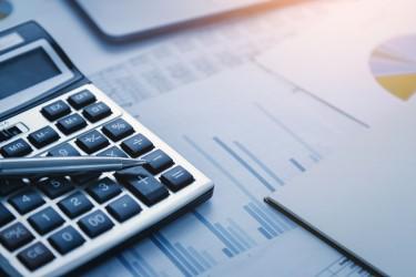 Image of a calculator, a pen, and various charts